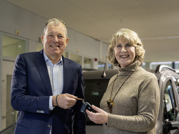 Vrouw krijgt de sleutels van een nieuwe auto overhandigd